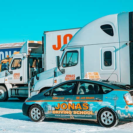 A car and trucks parked outside