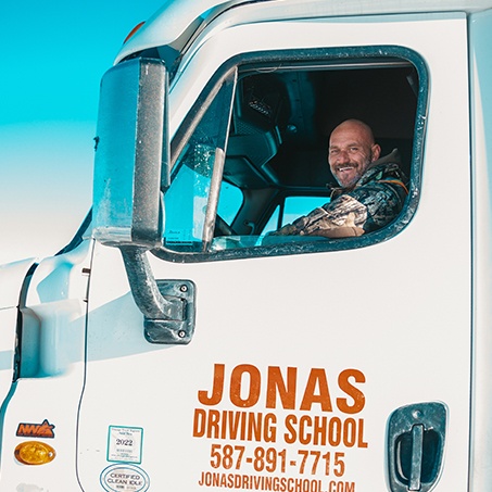 Student inside a truck sitting on driver's seat